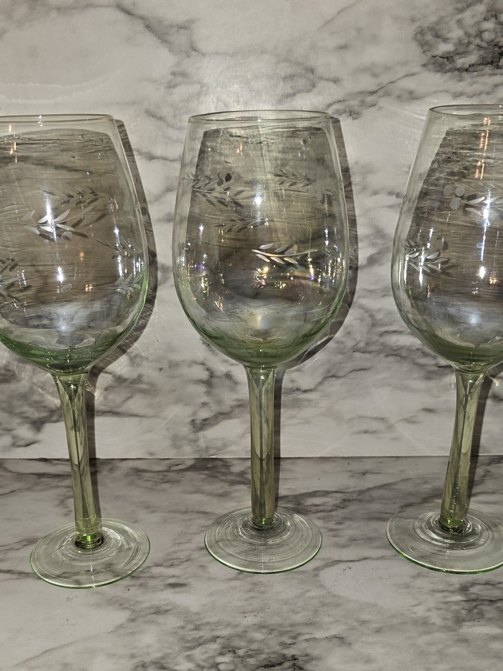 This set of three iridescent green blown glass wine glasses stands at 8.5 inches